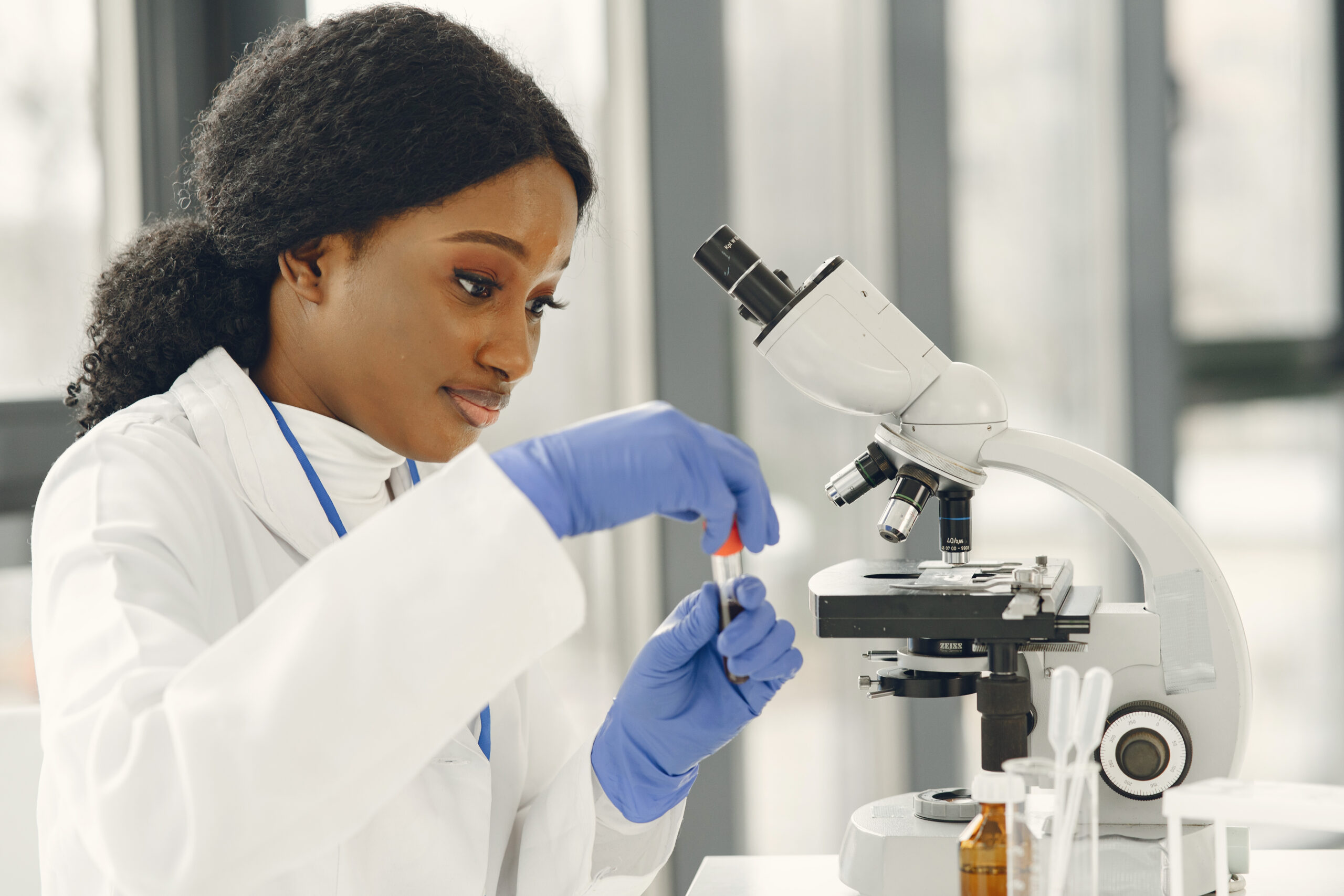 medical doctor girl working with microscope young female scientist doing vaccine research scaled